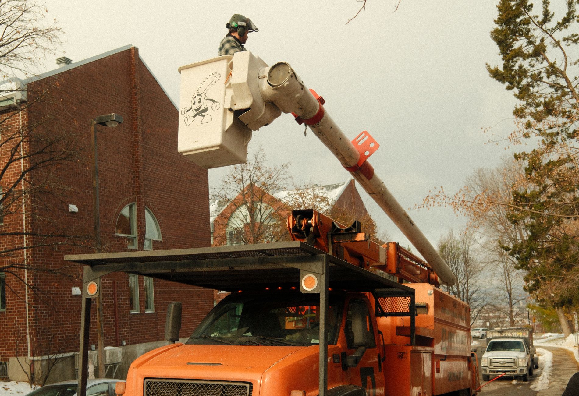 Arboriculteur d’Arbocomplet dans une nacelle, en train d’inspecter des arbres sans feuilles dans le quartier Montcalm à Québec après une première neige